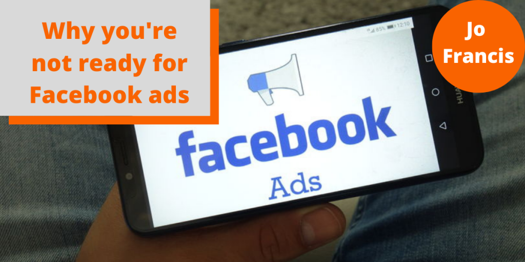 An image of a hand holding a mobile phone with the facebook ads logo on it. On the left side of the image there is an orange rectangle with a grey rectangle layered over the top with orange text reading ‘Why you’re not ready for Facebook ads’ and on the right side of the image there is an orange circle with white text reading ‘Jo Francis’